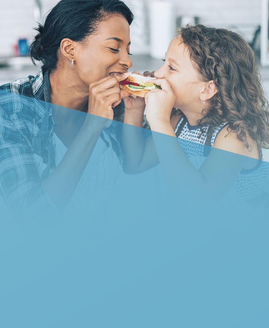 Stay Healthy banner displaying a women and child taking a bite of the same sandwich